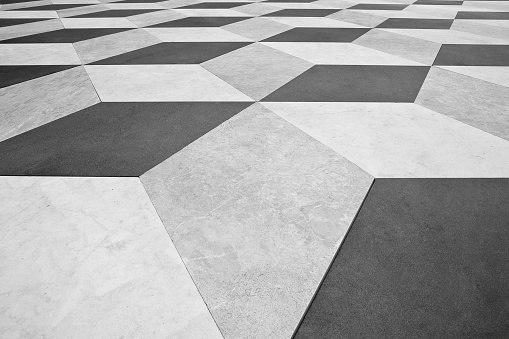 Modern paving made with stone blocks diamond-shaped white, black and gray in colour in a pedestrian zone
