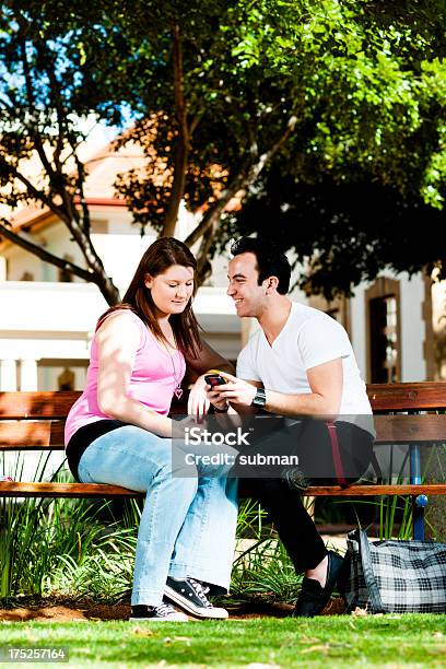 Studenti Sulla Panchina A Parlare - Fotografie stock e altre immagini di Abbigliamento casual - Abbigliamento casual, Adolescenza, Adulto