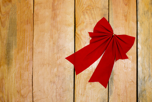 A Christmas decorative red bow on wood background