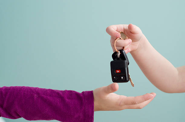 little manos dar y recibir las llaves del automóvil - conductor asignado fotografías e imágenes de stock