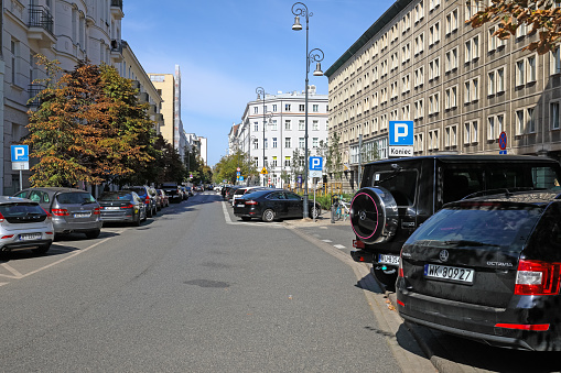 Warsaw, Poland - September 20, 2023: A road in the centre of the city with cars parked on both sides of it. There is no traffic on this street now.