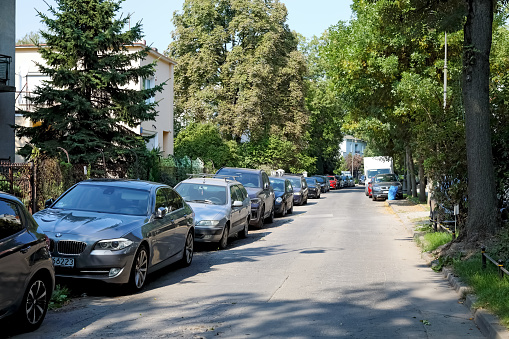Warsaw, Poland - September 13, 2023: A narrow street with almost no traffic now, but cars parked along it, part of the Saska Kepa housing estate in the Praga-Poludnie district.