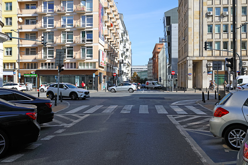Warsaw, Poland - September 20, 2023: Crossroads in the centre of Warsaw. There is now little traffic on the street, there are also parked cars, and residential buildings are visible.