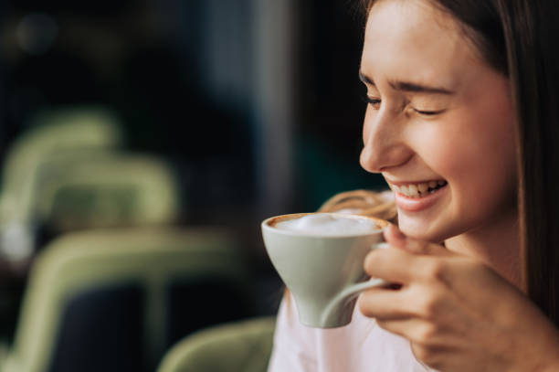 istock A young cheerful woman is laughing while drinking fresh coffee in a coffee shop. 1752585754