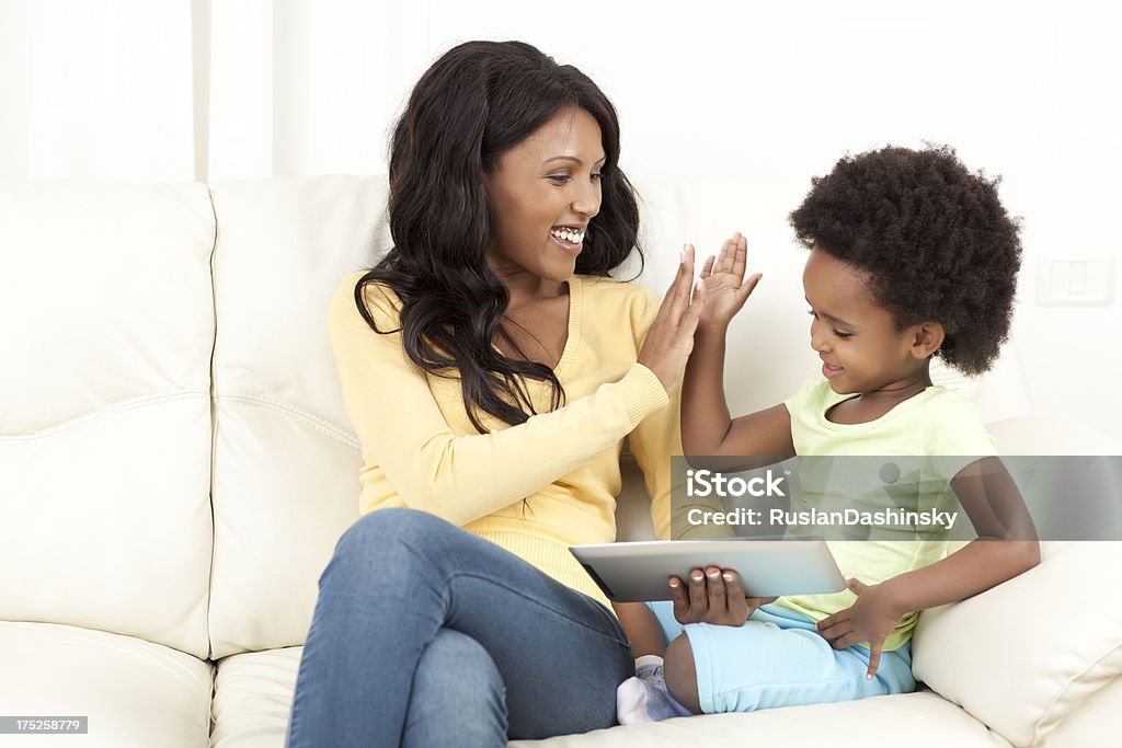 Madre e hija jugando en tableta digital. - Foto de stock de Choque de manos en el aire libre de derechos