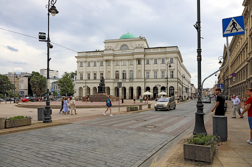 Warsaw, Poland - July 19, 2023: Staszic Palace on Nowy Swiat Street in the city centre. In front of the palace there is a monument to Nicolaus Copernicus by the Danish sculptor Bertel Thorvaldsen.