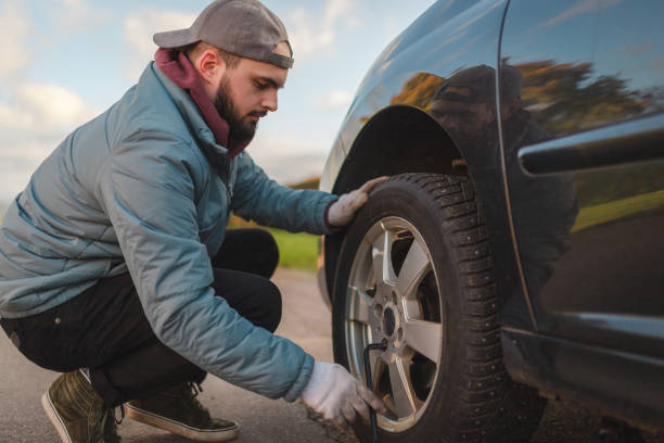 istock Young man unscrewing his car tire before replacing it 1752594864