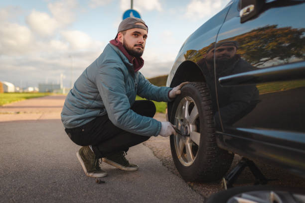 istock Young man unscrewing his car tire before replacing it 1752594870