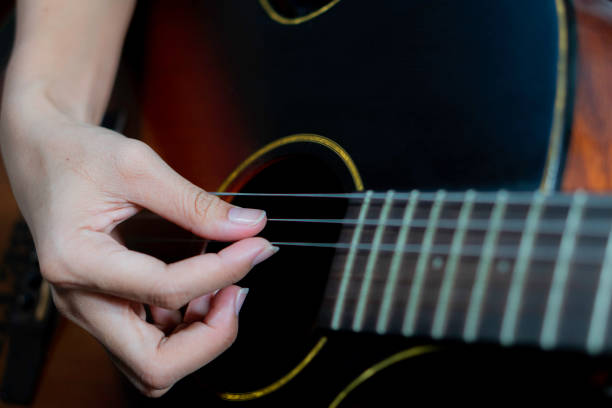 istock Young women playing acoustic guitar 1752599347