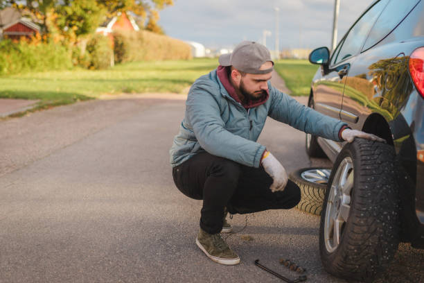 istock Young man inspecting the removed car tire before replacing it 1752601673
