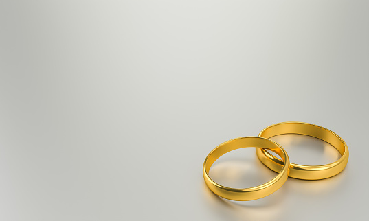 Illustration of two gold wedding rings with blank background for text. Unity and love concepts. 3d rendering