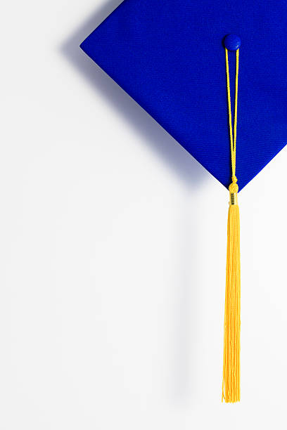 A blue graduation cap with a gold tassel stock photo