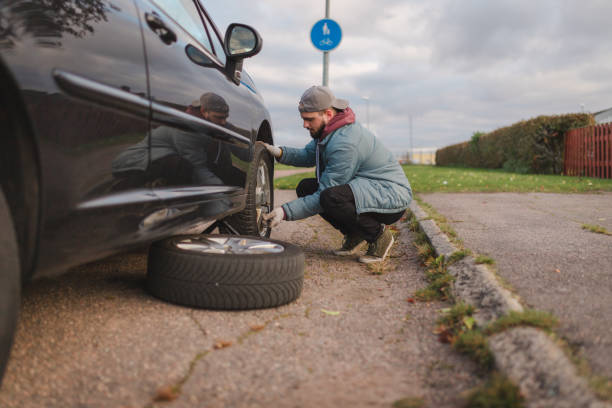 istock Young man unscrewing his car tires outdoors before replacing them 1752605785