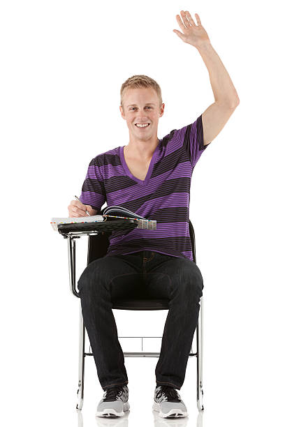 A primary school student is doing homework. The child at the desk with the textbook is angry. The boy does not want to study. A seven-year-old child goes crazy for lessons.