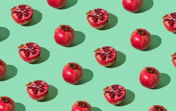 istock Trendy fruit pattern made of fresh red pomegranates on light pastel green background. Minimal healthy food layout. Nature fruit concept. Pomegranate aesthetic background pattern. 1752608652
