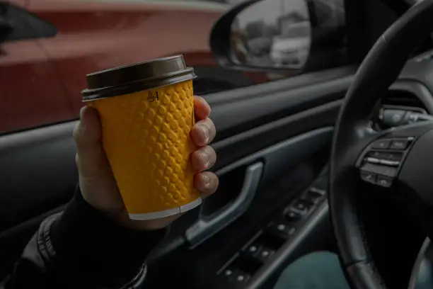 Photo of a man holds a coffee in his hand