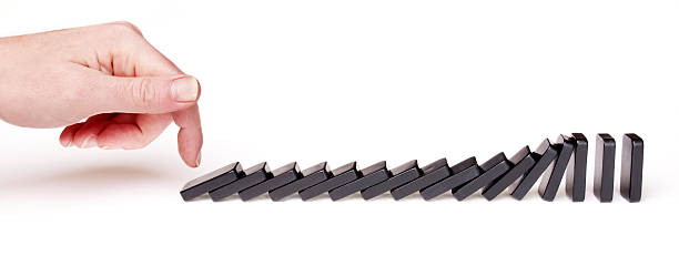 istock Man's Hand Toppling Dominoes 175261181