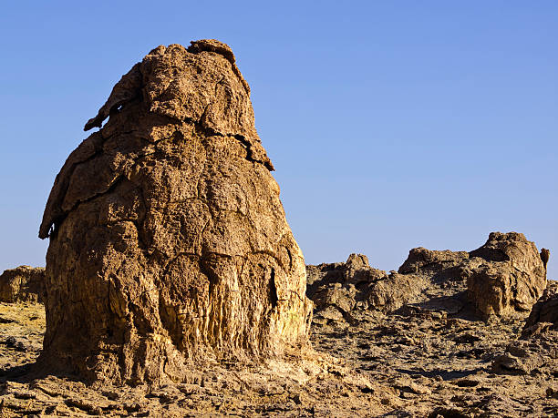 Rock house "At the top of the hill there are big rocks like houses. It is part of Volcanic remains which are after 1926 eruption like Hot Springs with geothermal / volcanic activity on Dallol Mountain. The characteristic white, yellow and red colours are the result of sulphur and potassium salts coloured by various ions. It is located in the Danakil Depression with the highest average temperatures on the planet and is considered the most remote and beautiful place on Earth, North East Ethiopia near Eritrea in Africa. This is the area whera the army and police protection is needed." dallol ethiopia stock pictures, royalty-free photos & images