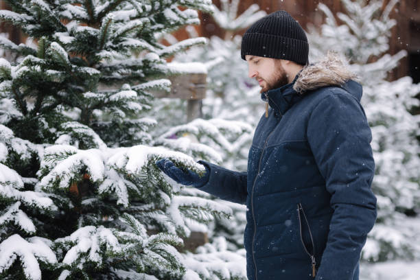 istock Handsome bearded man chooses a Christmas tree at the fair 1752612235