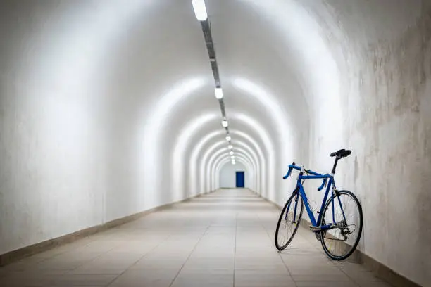 Photo of A blue road bike leaning against a white wall in an atomic shelter