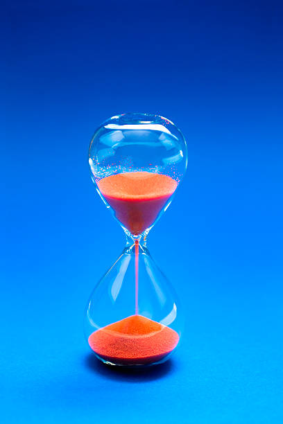 hourglass on blue background Hourglass on blu background timer stopwatch red isolated stock pictures, royalty-free photos & images