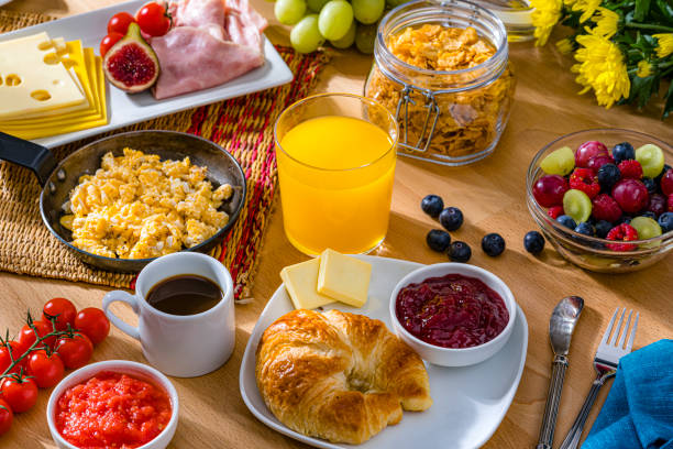 istock Delicious breakfast of scrambled eggs, cheese, ham, coffee, croissants and fruit juice 1752620721