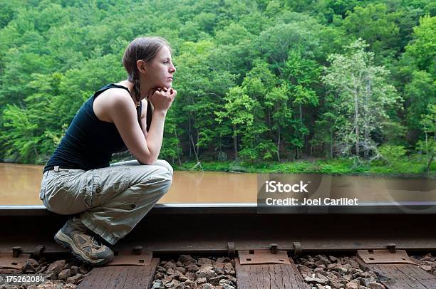 Foto de Menina Sentada Sobre Trilhos Da Estrada De Ferro e mais fotos de stock de Adolescentes Meninas - Adolescentes Meninas, Sentar, Perfil - Vista Lateral