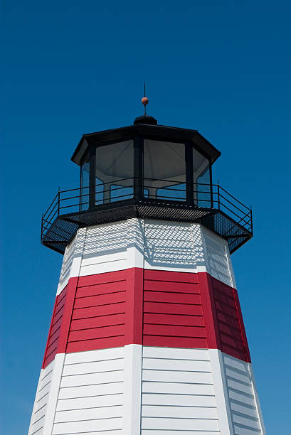 Vibrant lighthouse on a clear blue sky stock photo