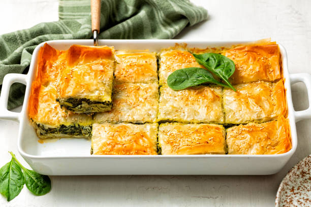 Casserol Spanakopita piece of pie, homemade Greek spinach pastry. With cheese feta, chopped spinach, green, egg, layered in phyllo or filo dought. Casserol Spanakopita piece of pie, homemade Greek spinach pastry. With cheese feta, chopped spinach, green, egg, layered in phyllo or filo dought. spanakopita stock pictures, royalty-free photos & images