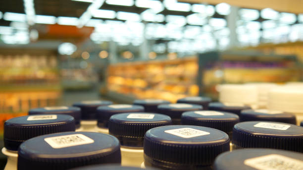 Close-up of many bottles of yogurt with dark blue caps on a store shelf stock photo