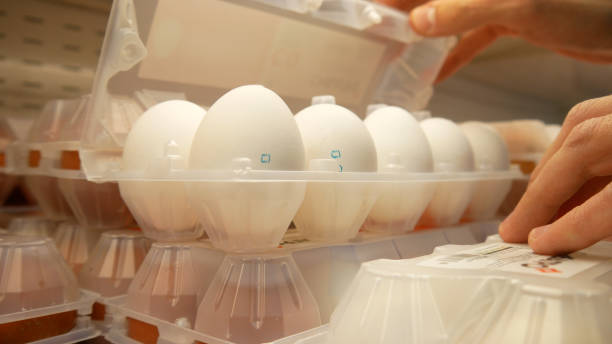 Close-up of a plastic packaging of eggs and two male hands open it to check the eggs integrity and then take it stock photo
