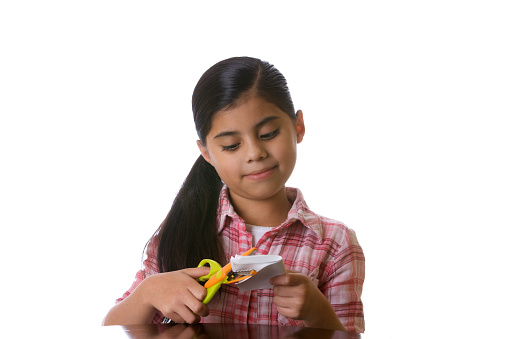 young girl cutting paper isolated on white