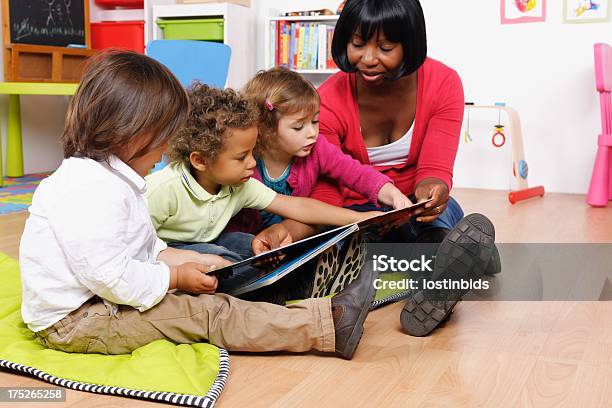 African American Accompagnatore E Gruppo Di Piccoli Bambini Leggere La Storia - Fotografie stock e altre immagini di Educazione di scuola materna