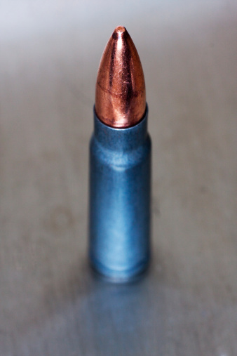 A solitary 7.62x39 (fits AK47) bullet on silver background.All images in this series...