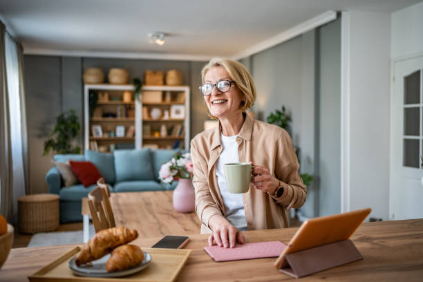 istock A mature woman uses a smartphone while sitting in her comfortable and modern apartment 1752662478