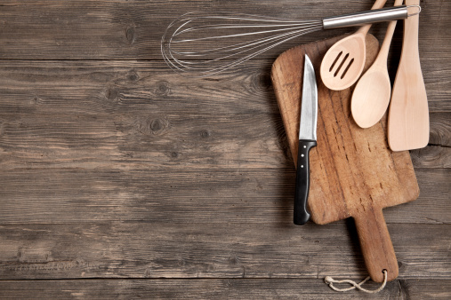 Kitchen utensils on an old wooden background