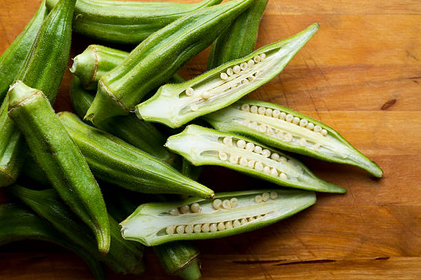 Close-up of pile of organic okra on wood Fresh Organic Okra healthy eating color image horizontal nobody stock pictures, royalty-free photos & images