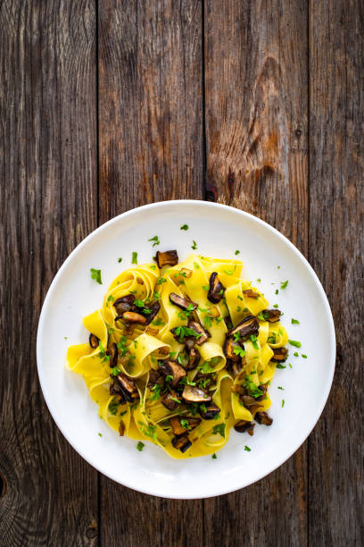 istock Tagliatelle with forest mushrooms on wooden table 1752676315