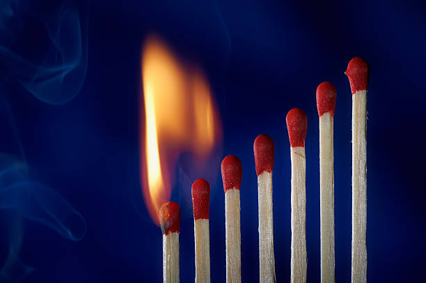 istock Wooden matches lined up like dominoes steps, in flames 175267679