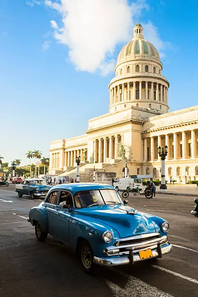 Cars speeding in front of El Capitolio in Havana, Cuba.