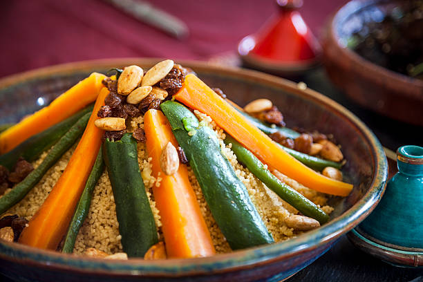 Vegetable couscous Vegetable couscous with toasted almonds and sultanas.  Authentic pepper and salt pots and table linen. couscous stock pictures, royalty-free photos & images