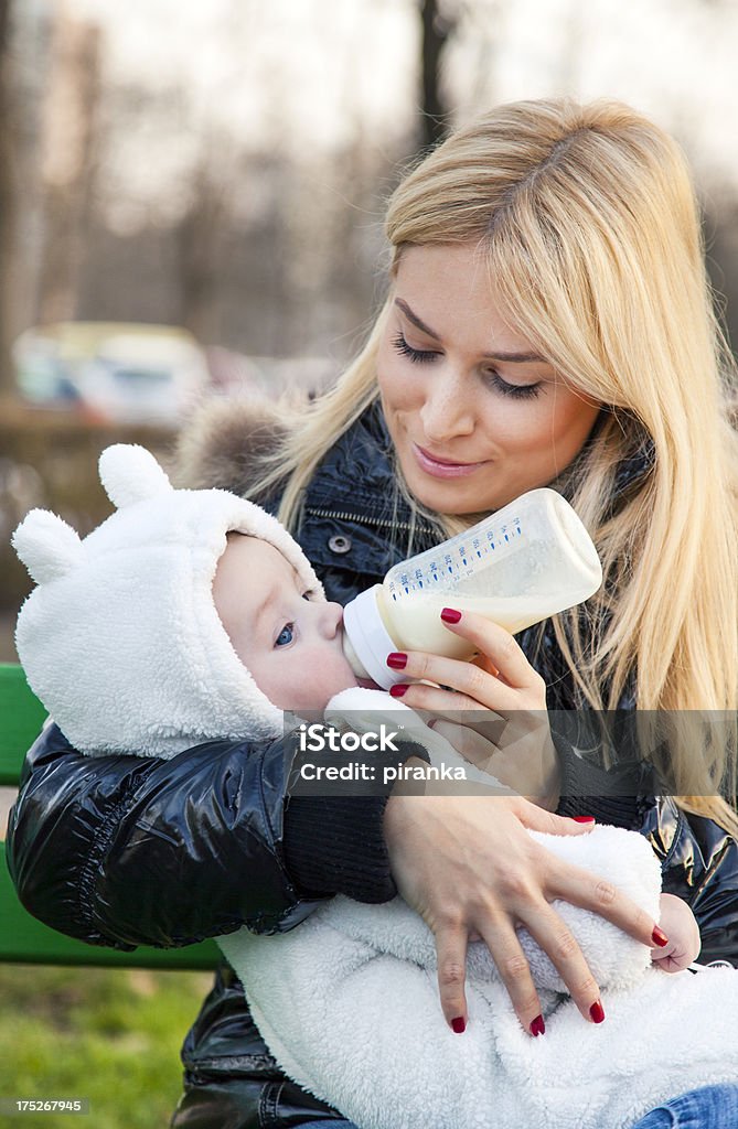 Jovem mãe alimentando o bebê - Foto de stock de Exterior royalty-free