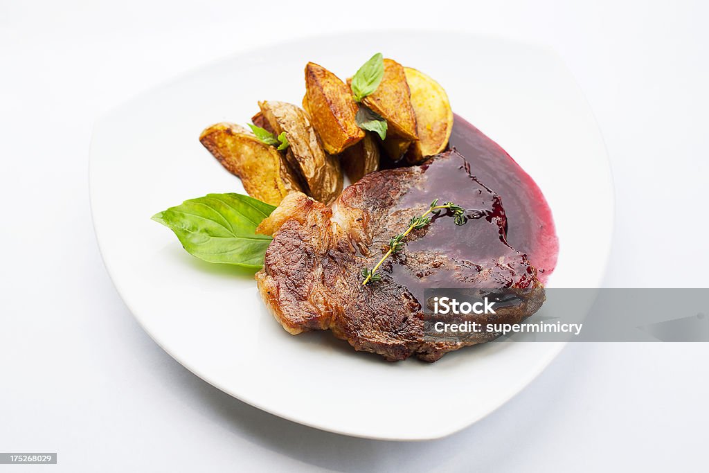 juicy steak juicy steak with cherry sauce and fried potato Plate Stock Photo