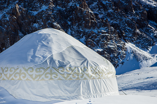 Kazakh yurt in the mountains near Almaty in the snow in winter. House of nomadic peoples in the mountains in winter.