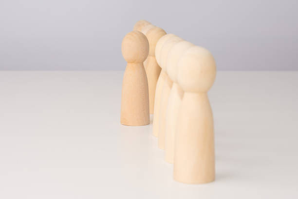 istock wooden men are displayed in a row on a light table, with free space for text 1752690178