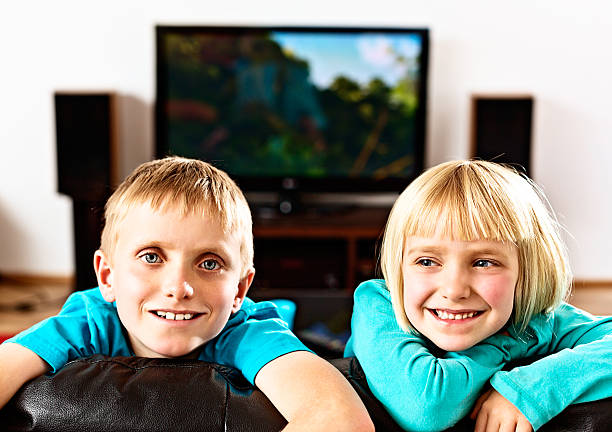 istock Blond elementary-age brother and sister playing on couch 175269087