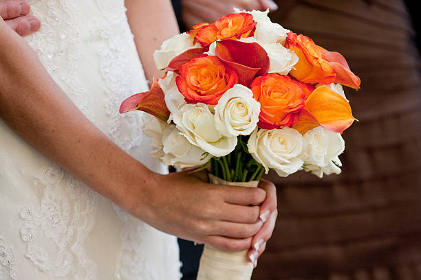 istock White and Orange Rose Wedding Bouquet in Bride's Hands 175269125
