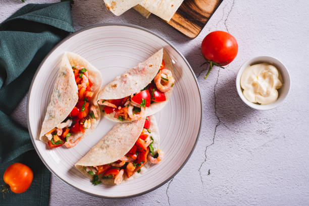 istock Vegetarian mini tacos with tomatoes, shrimp and herbs on a plate on the table top view 1752701431