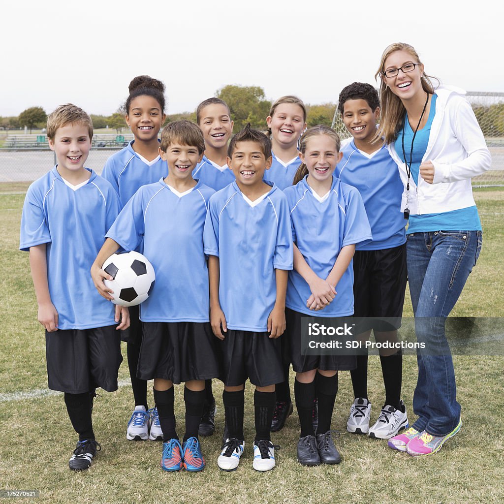 Liga de futebol jovens posando com ônibus após o jogo - Foto de stock de Esporte royalty-free