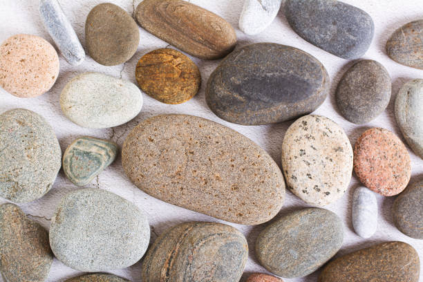 istock Flat lay background of smooth sea stones on a light background top view 1752709353